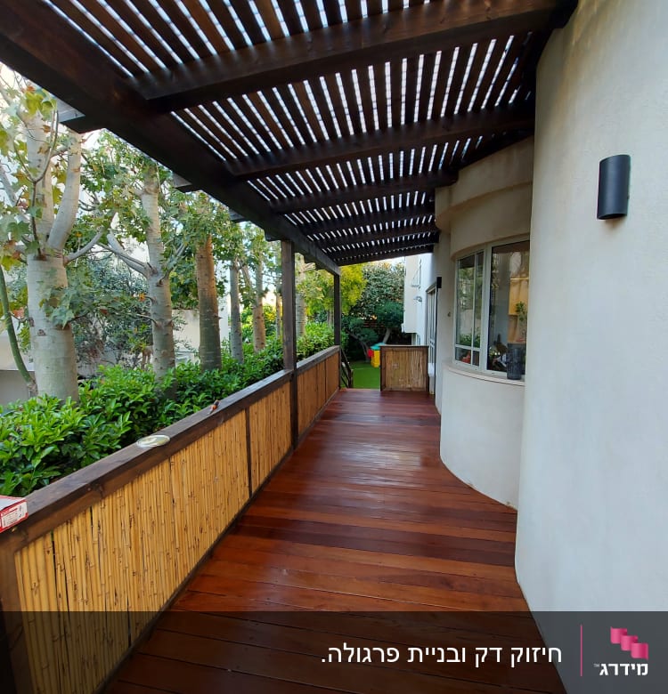 פרגולה מעץ עם רצפת דק וגדר במבוק